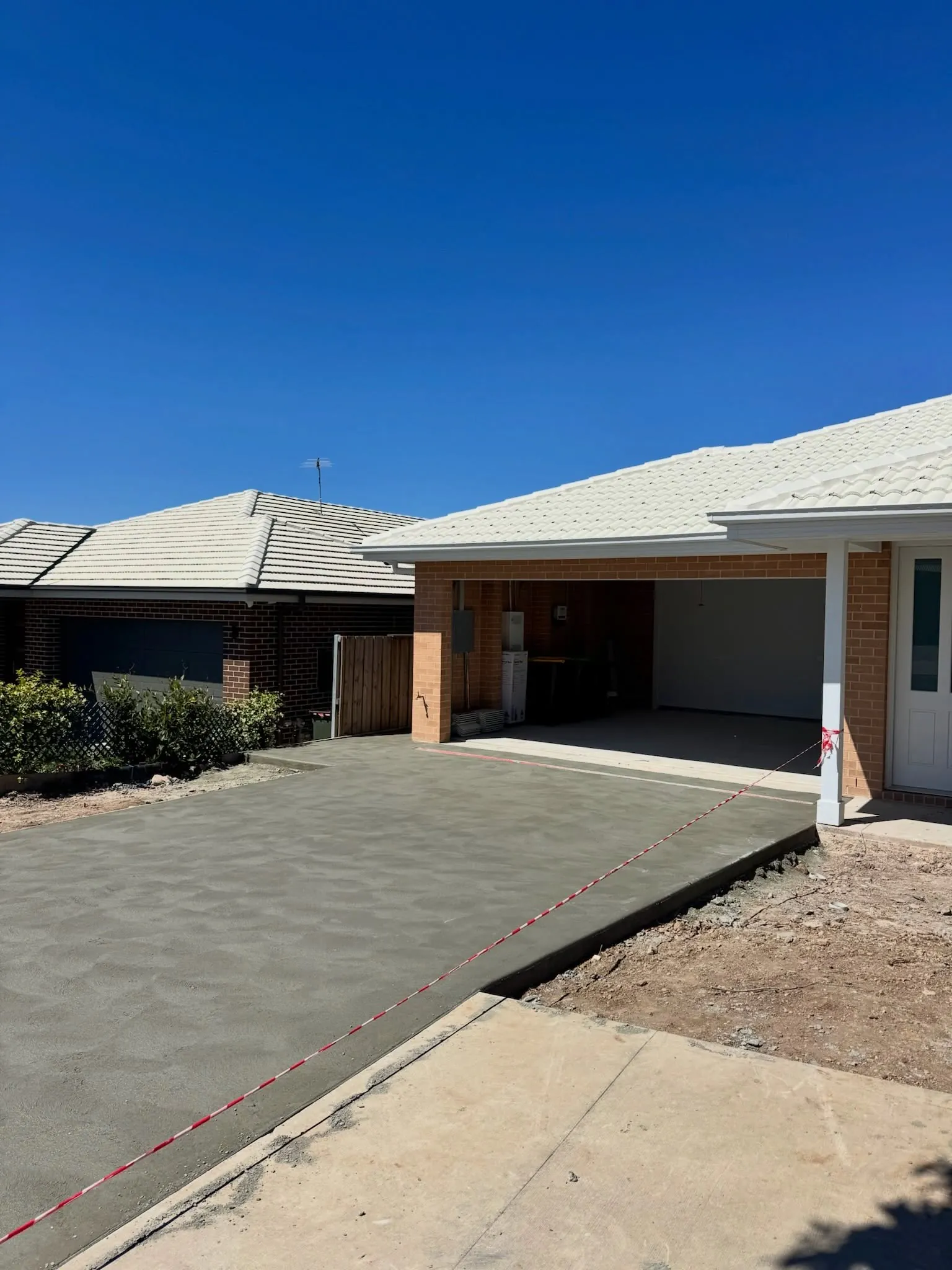 New concrete driveway in front of a double garage