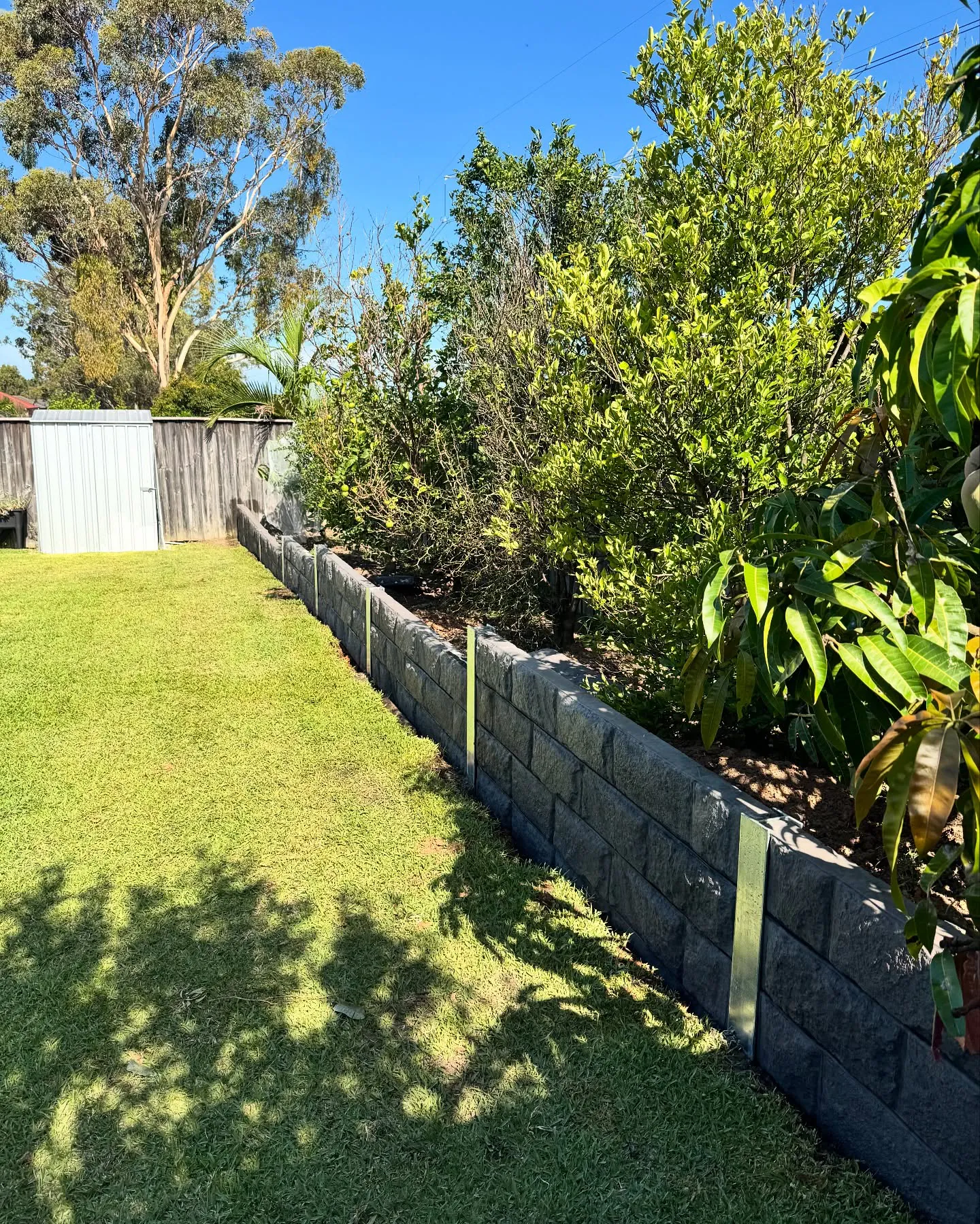 Block retaining wall along a lawn